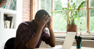 Man at a desk appearing frustrated. Cover image for a blog post titled Why Therapists are Leaving Insurance Networks